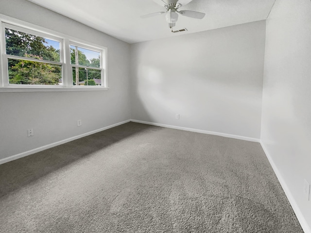 carpeted spare room with baseboards and a ceiling fan