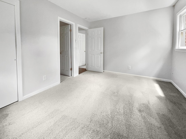 unfurnished bedroom featuring carpet flooring and baseboards