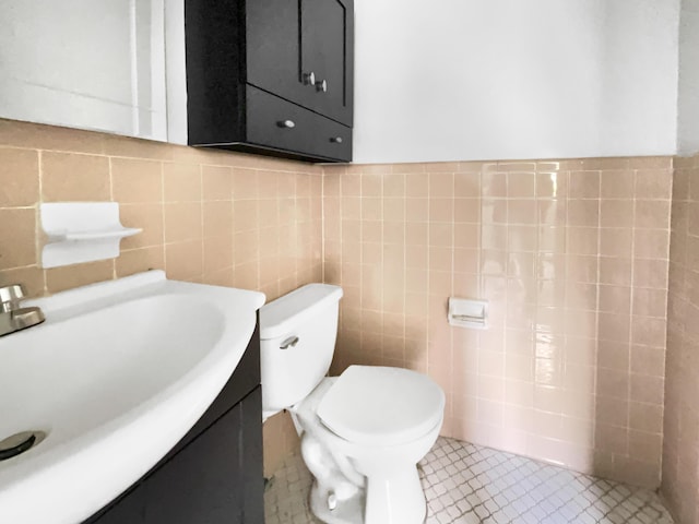 bathroom featuring tile patterned floors, toilet, tile walls, and vanity