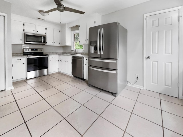 kitchen with visible vents, light tile patterned floors, white cabinets, stainless steel appliances, and a ceiling fan