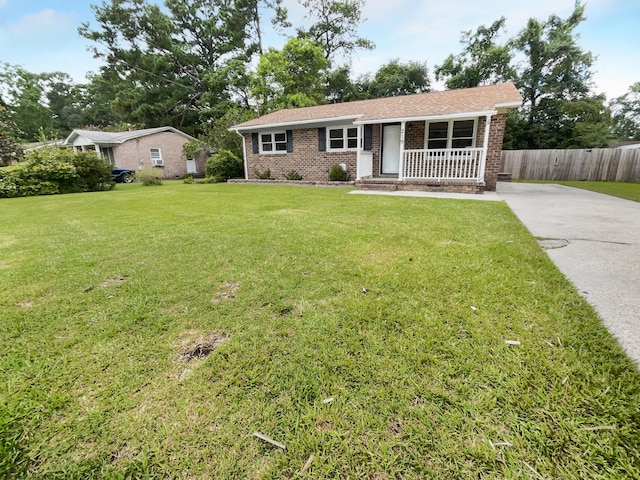 ranch-style home with brick siding, a porch, a front yard, and fence