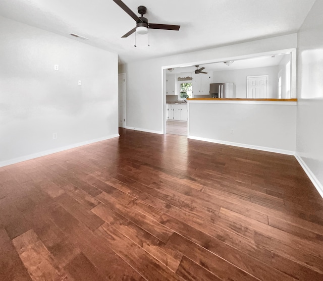 unfurnished living room with visible vents, wood finished floors, baseboards, and ceiling fan