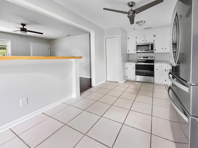 kitchen with light tile patterned floors, stainless steel appliances, a ceiling fan, and light countertops