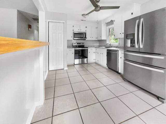 kitchen with stainless steel appliances, a ceiling fan, light tile patterned flooring, and white cabinets