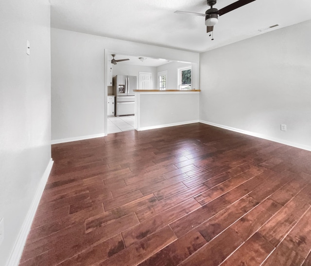 unfurnished living room featuring visible vents, baseboards, a ceiling fan, and wood finished floors