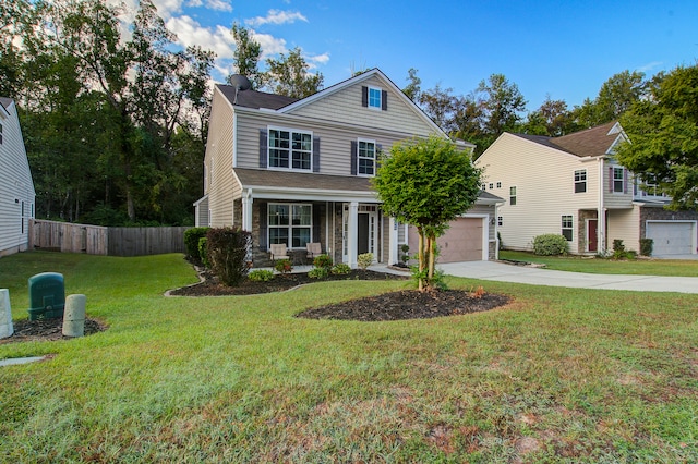 view of property featuring a front yard, a garage, and covered porch