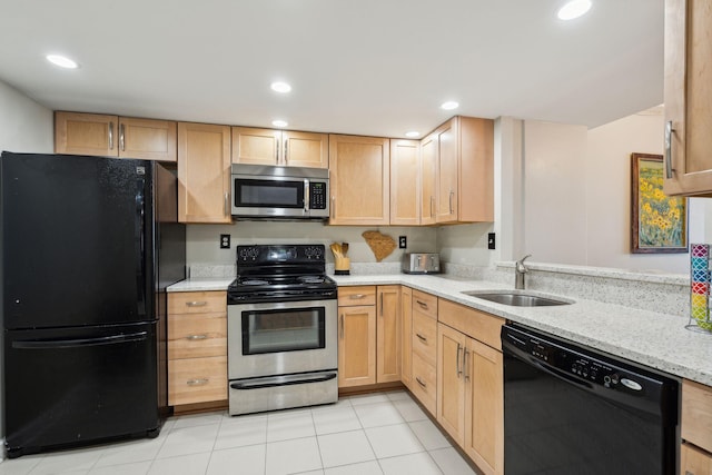 kitchen with black appliances, light stone counters, a sink, and recessed lighting