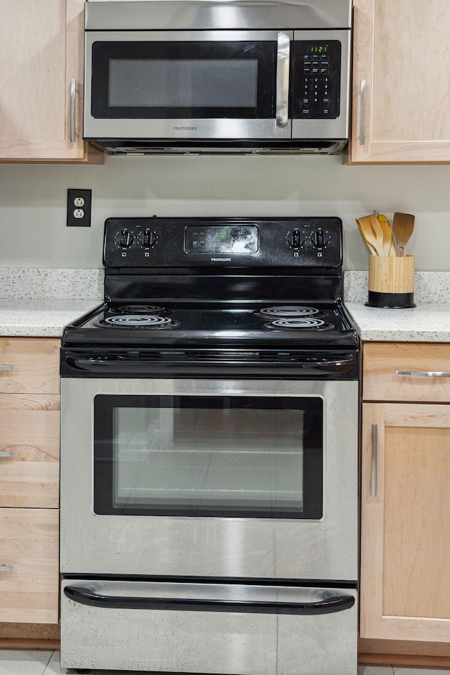 kitchen featuring light countertops, appliances with stainless steel finishes, and light brown cabinetry