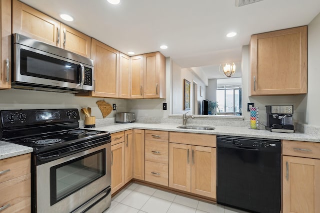 kitchen featuring appliances with stainless steel finishes, light stone countertops, light brown cabinetry, a sink, and recessed lighting