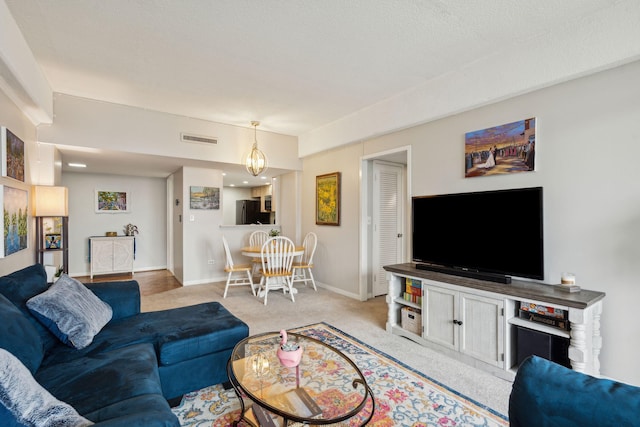 living room featuring baseboards, visible vents, and light colored carpet