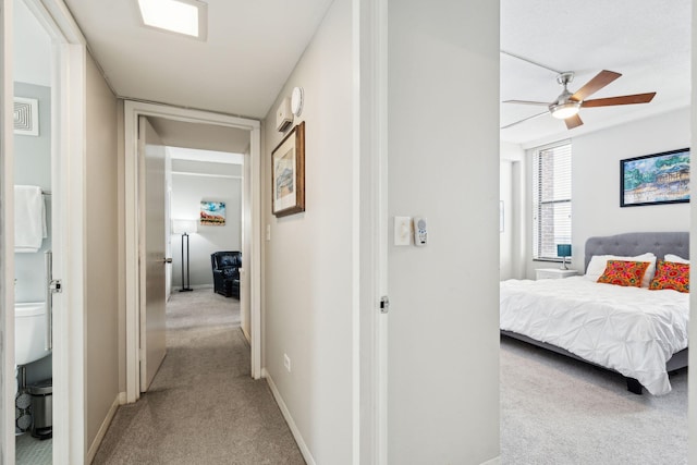 hall featuring light carpet and baseboards