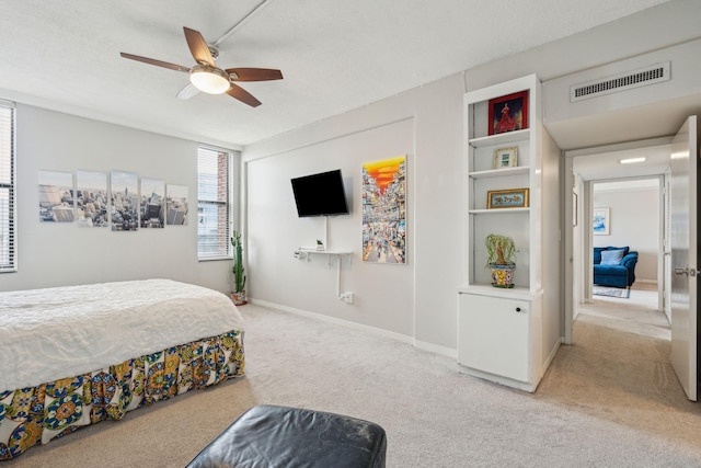 bedroom with light carpet, baseboards, visible vents, ceiling fan, and a textured ceiling