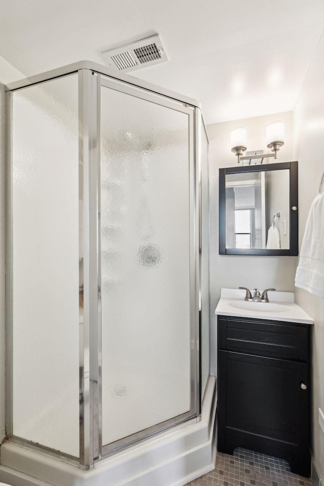 bathroom with tile patterned floors, visible vents, an enclosed shower, and vanity