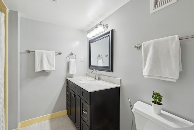 full bath with toilet, tile patterned floors, baseboards, and vanity