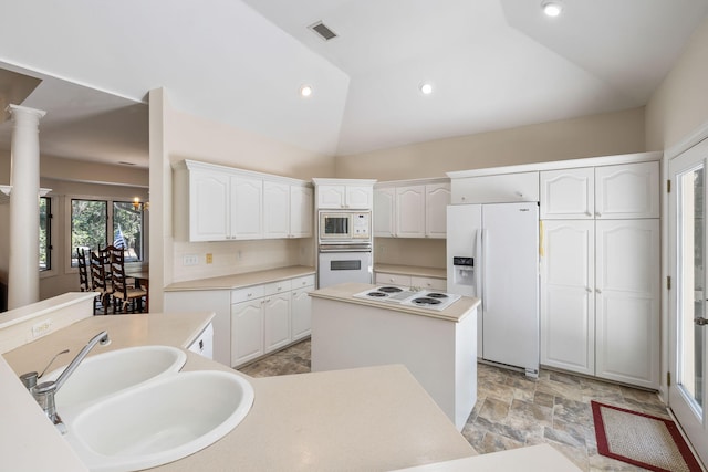 2938 Old Drake Dr, Seabrook Island, SC 29455 - kitchen with white appliances, a kitchen island, lofted ceiling, white cabinetry, and light stone finish flooring