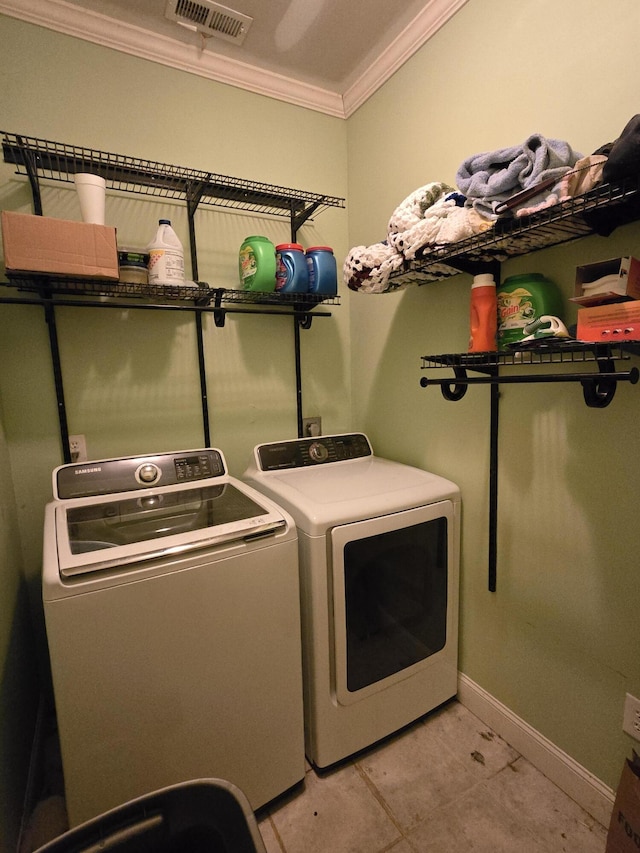 washroom featuring washer and dryer, light tile patterned floors, and crown molding