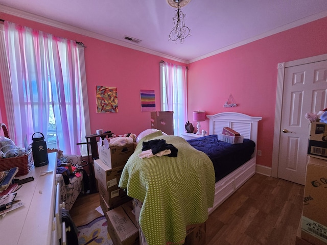 bedroom featuring a chandelier, ornamental molding, and dark wood-type flooring