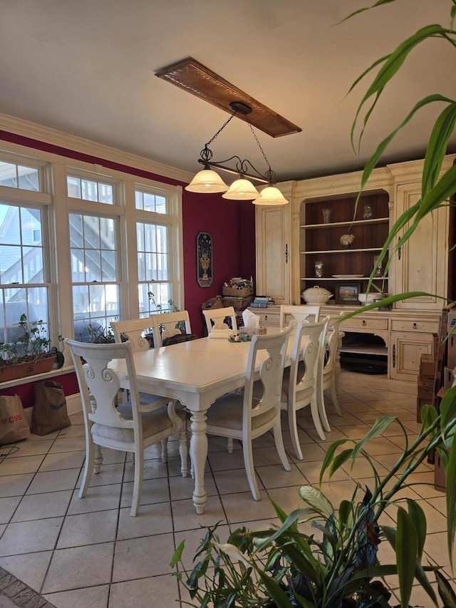 dining room featuring light tile patterned floors and ornamental molding