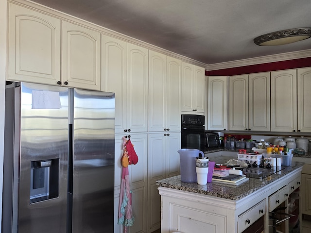 kitchen featuring stainless steel refrigerator with ice dispenser, wall oven, crown molding, dark stone countertops, and black oven