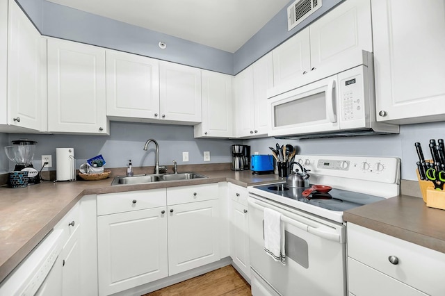 kitchen featuring light wood-type flooring, white appliances, white cabinetry, and sink