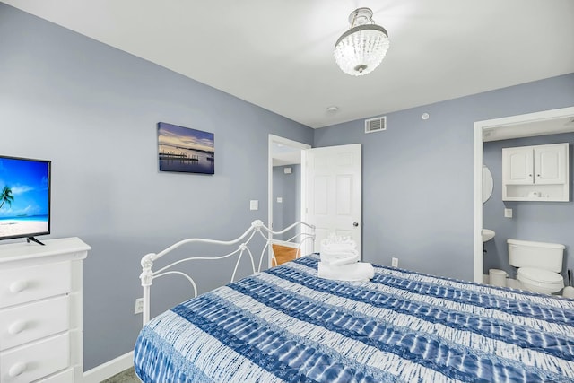 bedroom with connected bathroom and an inviting chandelier