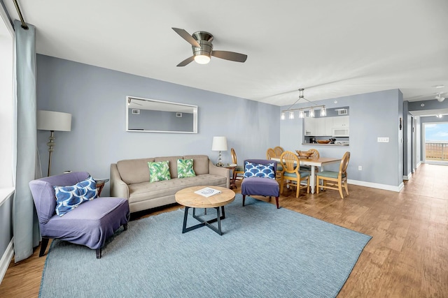 living room featuring ceiling fan and light hardwood / wood-style floors