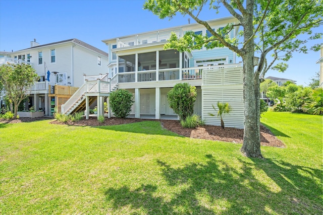 rear view of property with stairway, a sunroom, and a yard