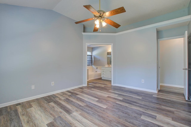 unfurnished bedroom featuring lofted ceiling, ceiling fan, ensuite bath, and hardwood / wood-style flooring