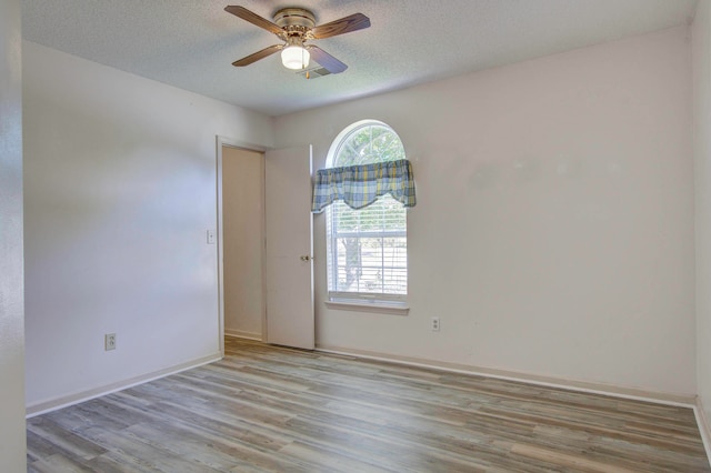 unfurnished room featuring ceiling fan, light hardwood / wood-style floors, and a textured ceiling