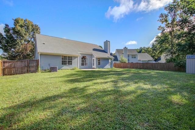 back of house featuring a lawn and central AC unit