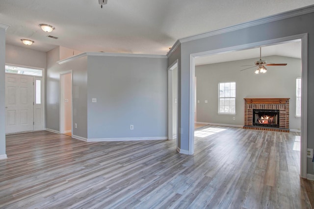 unfurnished living room with hardwood / wood-style floors, ceiling fan, a brick fireplace, and vaulted ceiling