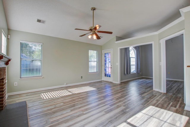 unfurnished living room with a brick fireplace, vaulted ceiling, hardwood / wood-style floors, ceiling fan, and a textured ceiling