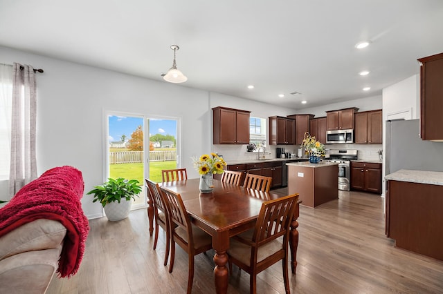 dining room with light hardwood / wood-style floors and sink