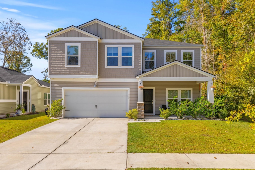 craftsman house with a front lawn and a garage