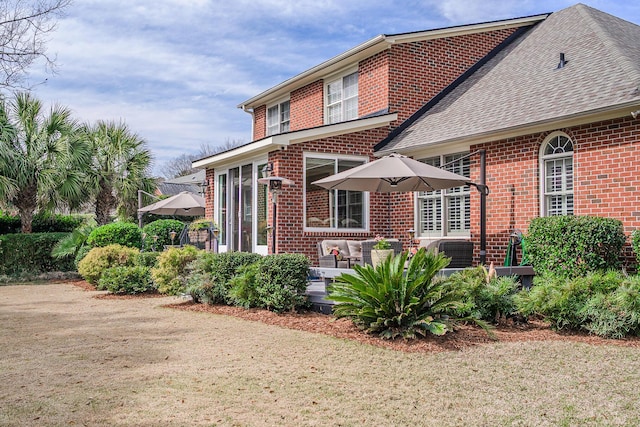 view of front of house with brick siding and a shingled roof