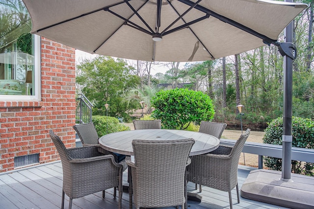 wooden deck with outdoor dining area and visible vents