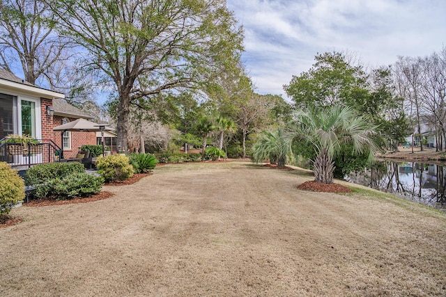 view of yard with a water view and dirt driveway