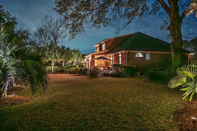 view of home's exterior featuring brick siding and a yard