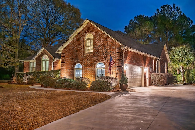 view of front facade with brick siding, driveway, and an attached garage