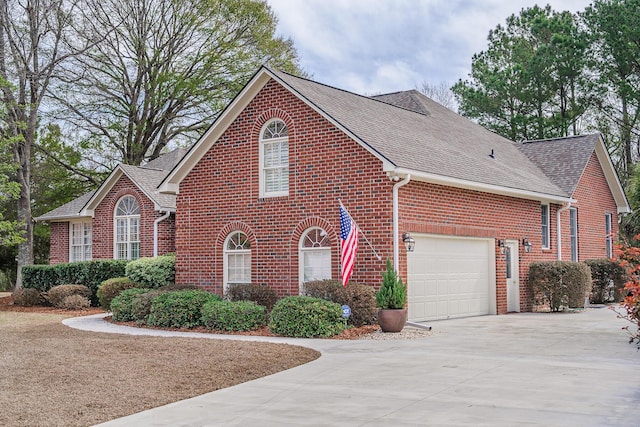 view of front facade with an attached garage, brick siding, roof with shingles, and driveway