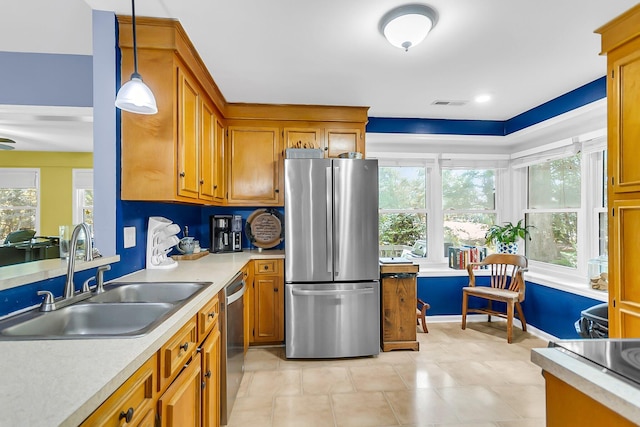 kitchen featuring a sink, brown cabinetry, visible vents, light countertops, and appliances with stainless steel finishes