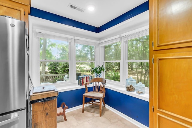 sitting room featuring light tile patterned flooring, a wealth of natural light, baseboards, and visible vents