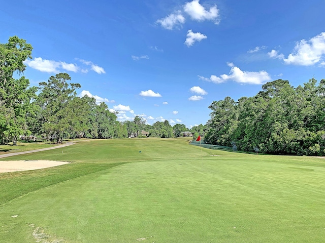 view of home's community with a yard and view of golf course