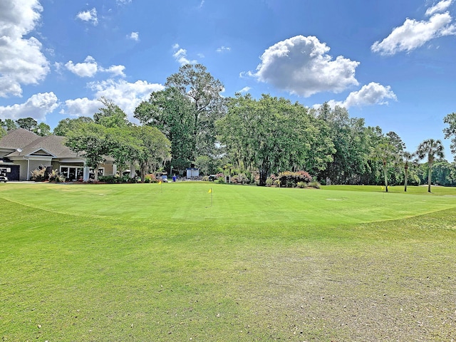 surrounding community with a yard and golf course view