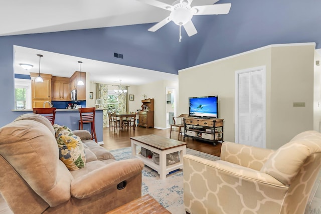 living room with high vaulted ceiling, light wood-style flooring, visible vents, and ceiling fan with notable chandelier