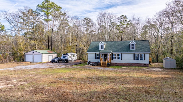 cape cod-style house with a garage, a front lawn, and a shed