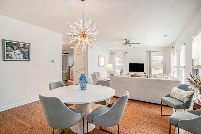 dining room featuring ceiling fan with notable chandelier and light wood-type flooring