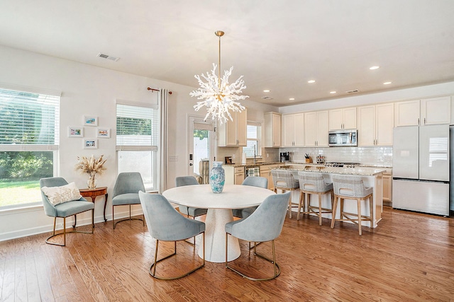 dining area featuring plenty of natural light, light hardwood / wood-style floors, and a chandelier