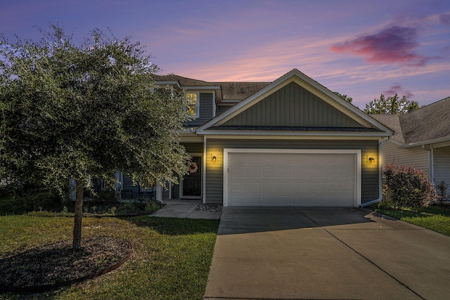 view of front of home with a garage and a yard