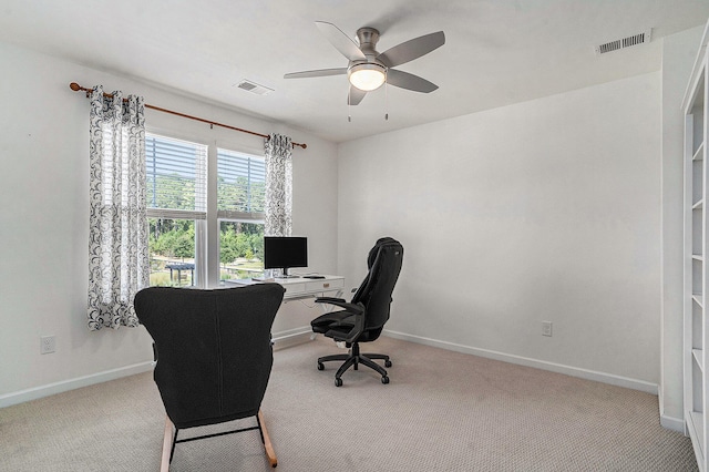 carpeted office space featuring ceiling fan